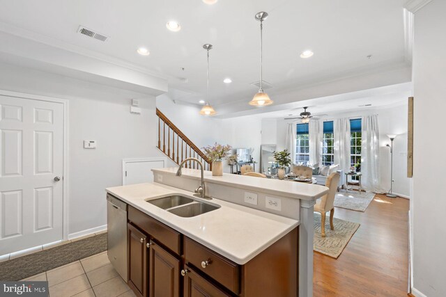 kitchen featuring hanging light fixtures, a sink, light countertops, a ceiling fan, and visible vents