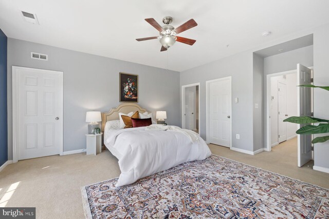bedroom featuring baseboards, light colored carpet, and visible vents
