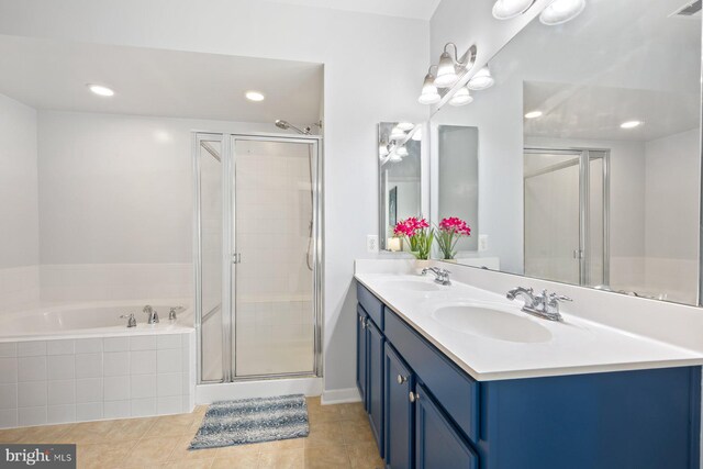 bathroom with tile patterned flooring, a sink, a garden tub, and a shower stall