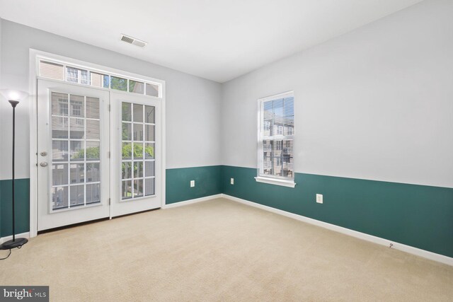 spare room with baseboards, visible vents, and carpet