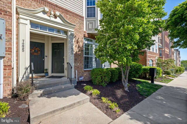 view of exterior entry with brick siding