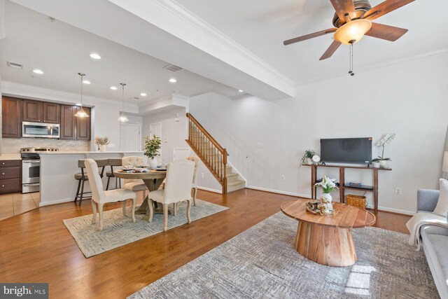 living room with visible vents, ornamental molding, and stairway