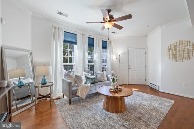 living room with a ceiling fan, visible vents, wood finished floors, a baseboard radiator, and ornamental molding