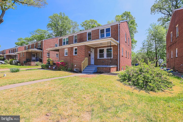 view of front facade with brick siding and a front lawn
