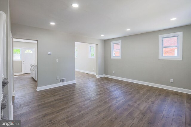 interior space featuring recessed lighting, baseboards, dark wood-style flooring, and a wealth of natural light