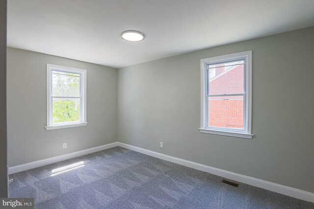 unfurnished room with plenty of natural light, carpet flooring, baseboards, and visible vents