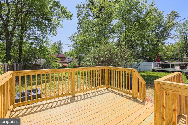 deck with a lawn and a fenced backyard