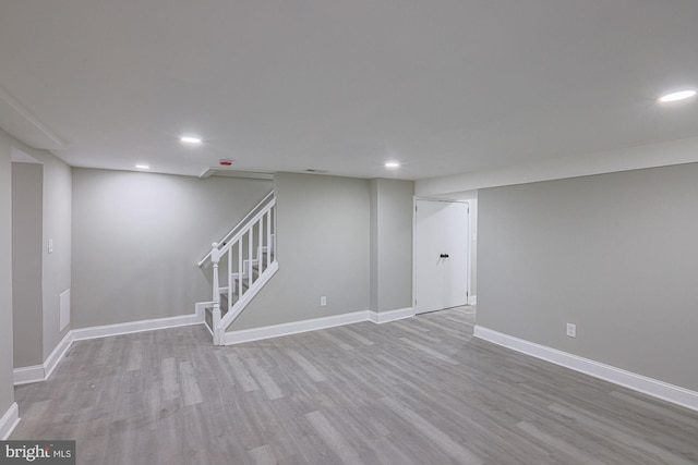 finished below grade area featuring recessed lighting, baseboards, wood finished floors, and stairway