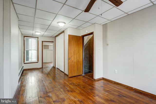 interior space featuring a paneled ceiling, a ceiling fan, baseboards, a baseboard radiator, and hardwood / wood-style flooring