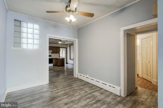 spare room featuring a ceiling fan, wood finished floors, baseboard heating, and ornamental molding