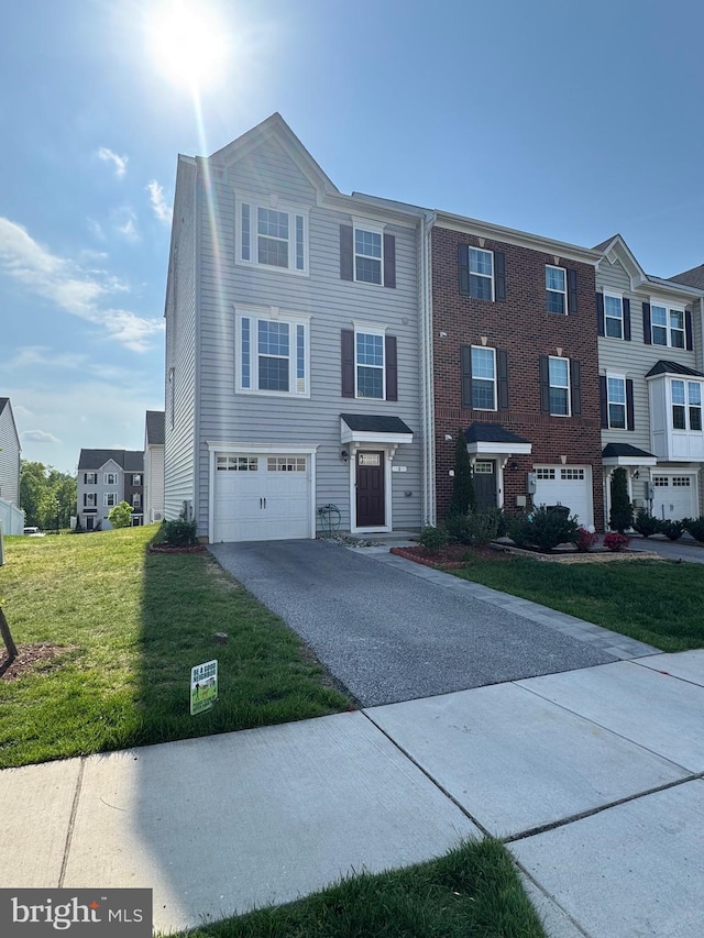 townhome / multi-family property with asphalt driveway, a garage, a front yard, and brick siding