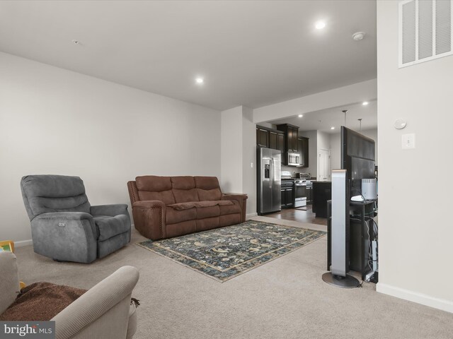 living area featuring dark carpet, recessed lighting, and baseboards