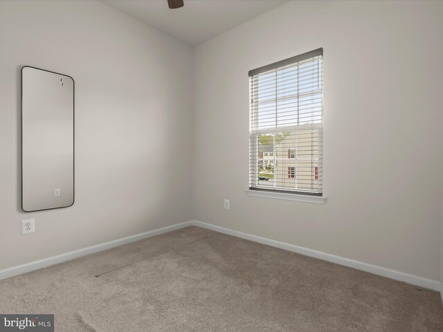 empty room with carpet floors, baseboards, and a ceiling fan