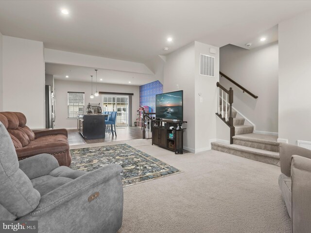 living area with recessed lighting, light carpet, stairway, and baseboards