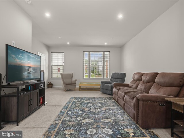 living area featuring light colored carpet, recessed lighting, and baseboards