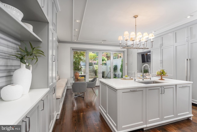 interior space featuring a sink, french doors, dark wood-style flooring, and a notable chandelier
