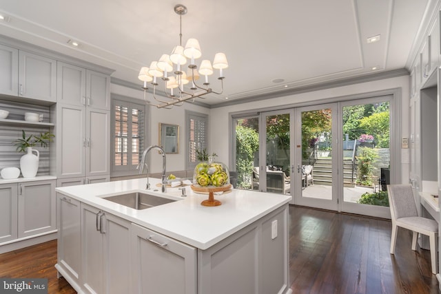 kitchen featuring dark wood-type flooring, light countertops, a sink, a notable chandelier, and gray cabinetry