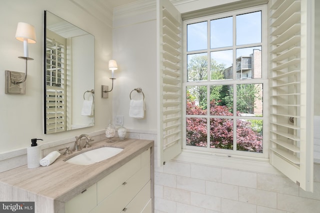 bathroom with vanity, ornamental molding, and a healthy amount of sunlight