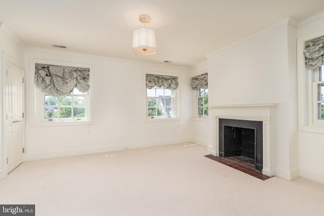 unfurnished living room with crown molding, carpet floors, and a wealth of natural light