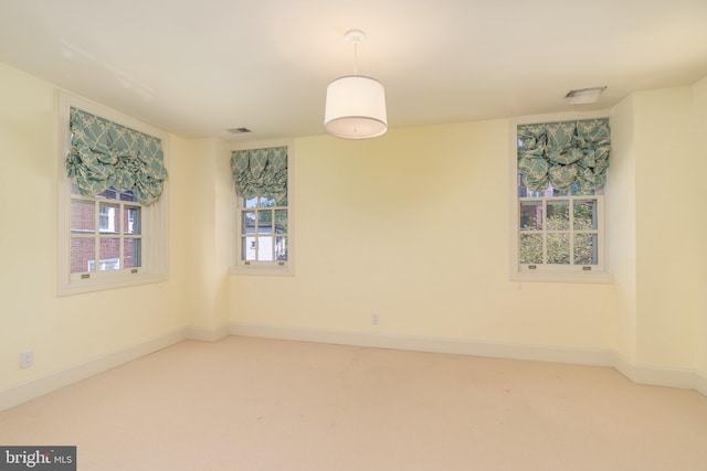 carpeted spare room with baseboards and visible vents