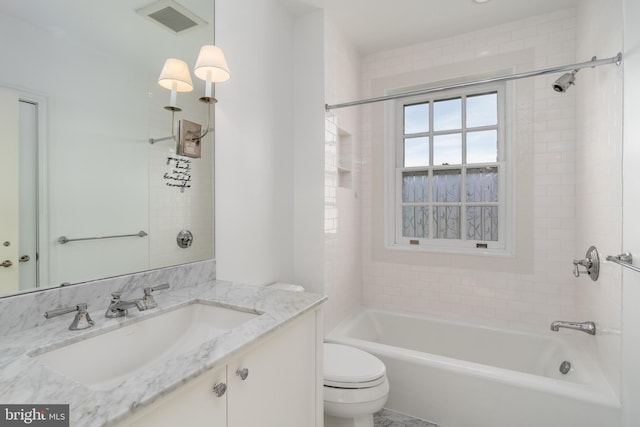 bathroom featuring vanity, toilet,  shower combination, and visible vents