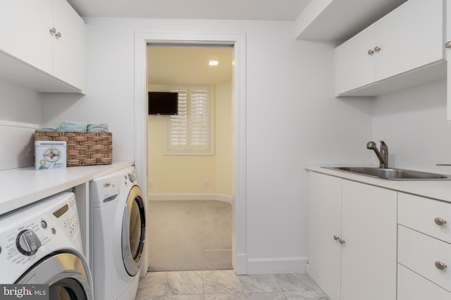 washroom featuring marble finish floor, baseboards, washer and clothes dryer, a sink, and cabinet space