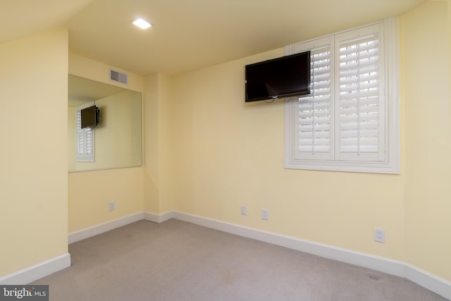 spare room featuring carpet floors, baseboards, and visible vents