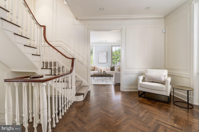 interior space with crown molding, baseboards, and a decorative wall