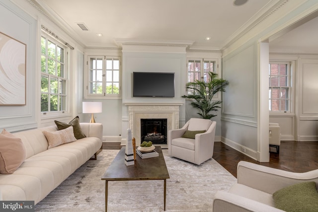 living room featuring visible vents, crown molding, a healthy amount of sunlight, and a fireplace