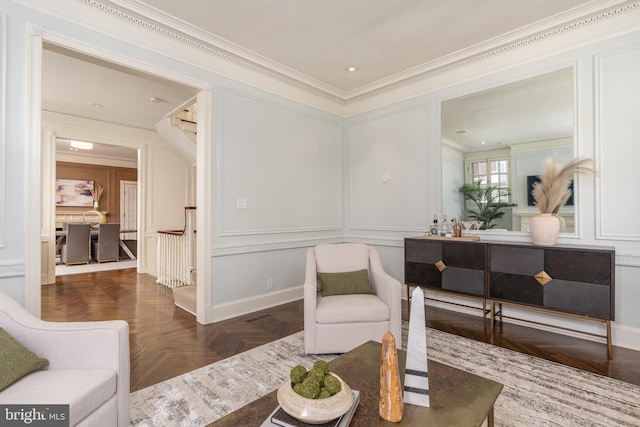 living room with ornamental molding, stairs, and a decorative wall