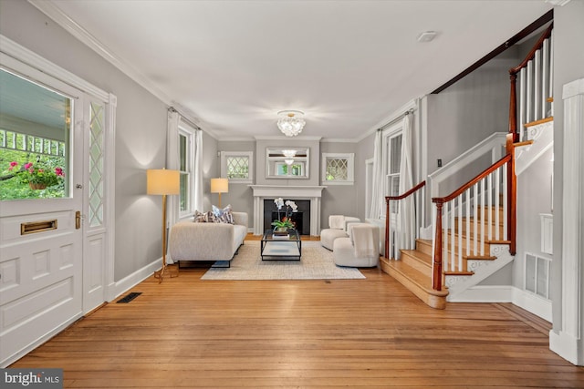 6763 25th St N, Arlington, VA 22213 - living area featuring stairway, crown molding, light wood-type flooring, a chandelier, and baseboards