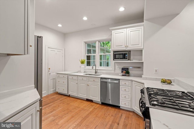 6763 25th St N, Arlington, VA 22213 - kitchen featuring appliances with stainless steel finishes, a sink, white cabinetry, light wood finished floors, and recessed lighting
