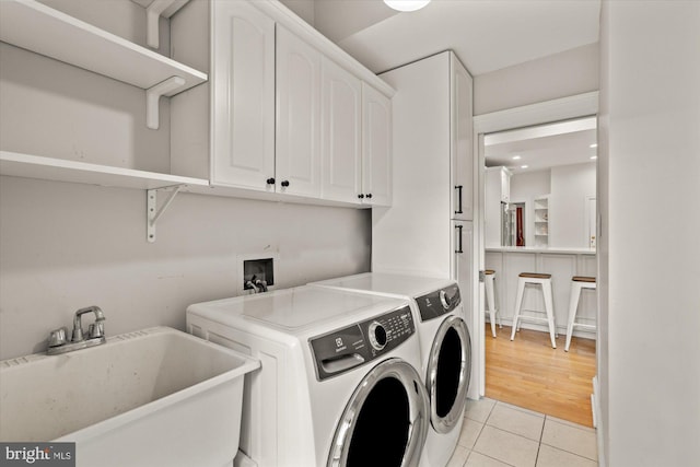 6763 25th St N, Arlington, VA 22213 - washroom with cabinet space, washer and dryer, and light tile patterned flooring