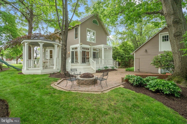 6763 25th St N, Arlington, VA 22213 - rear view of house featuring an outdoor fire pit, a patio, a lawn, a sunroom, and a gazebo