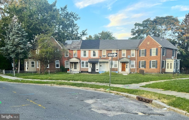 multi unit property with brick siding and a front lawn