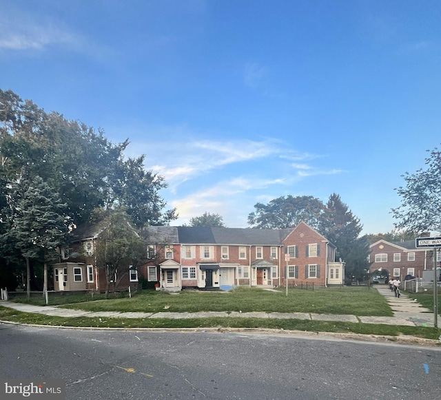 townhome / multi-family property with a front yard
