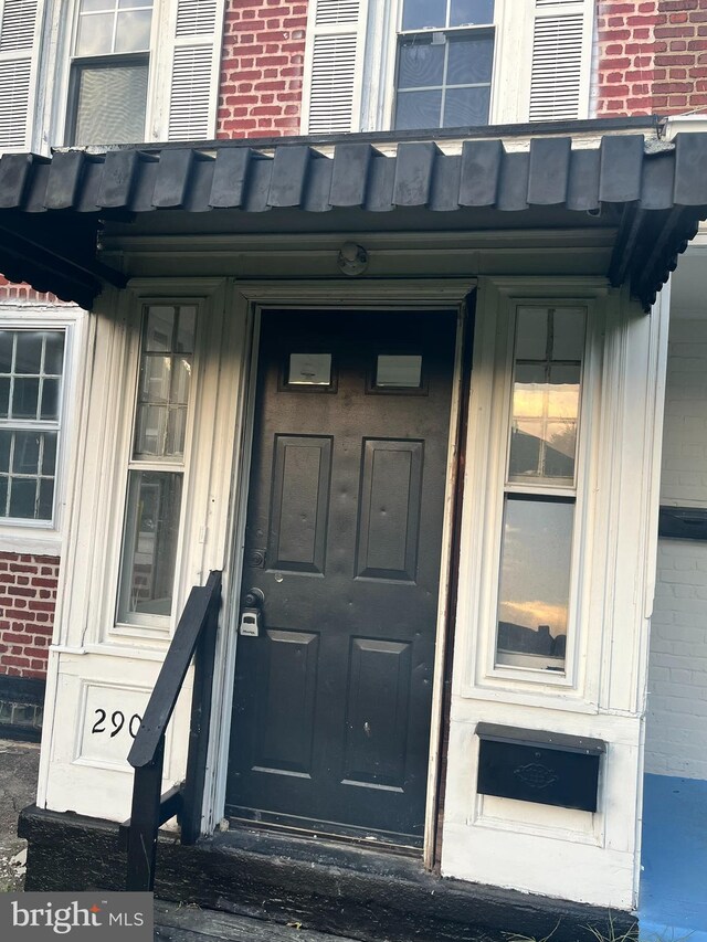 view of exterior entry with brick siding