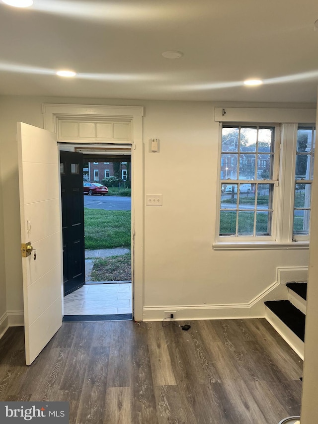 foyer entrance with baseboards and dark wood-type flooring