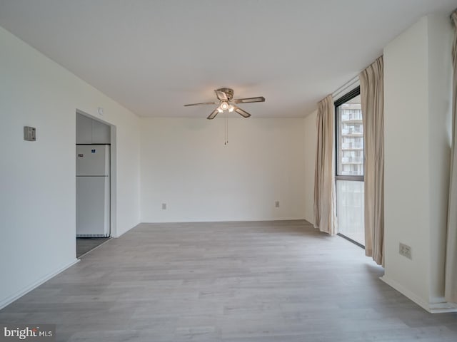 spare room with ceiling fan and light wood-style flooring