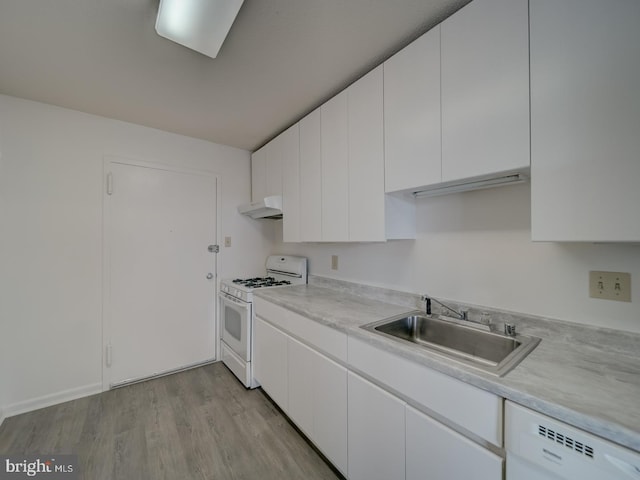 kitchen with white cabinets, a sink, white appliances, light countertops, and under cabinet range hood