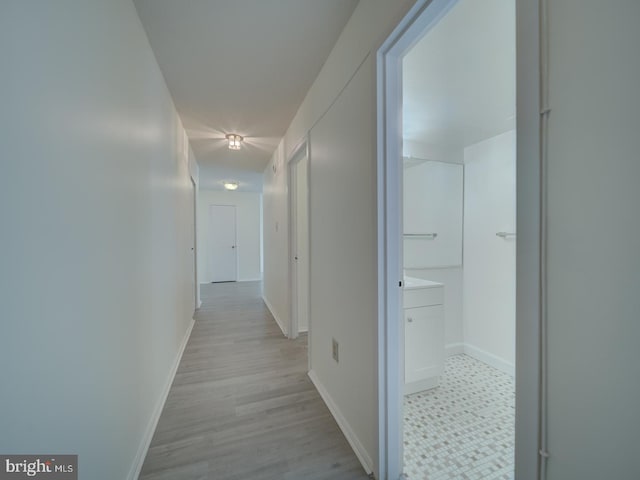 hall featuring baseboards and light wood finished floors