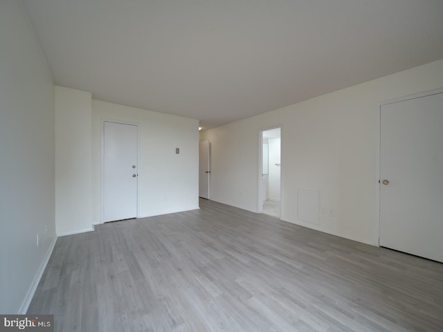 empty room with baseboards and wood finished floors