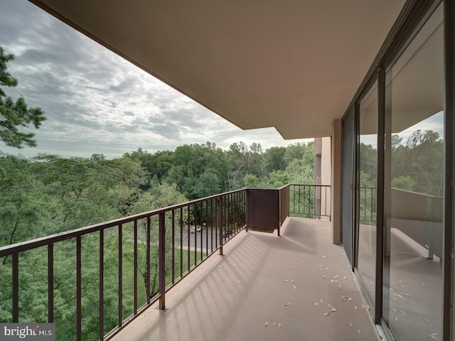 balcony featuring a wooded view