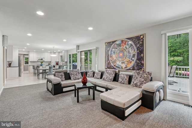 living room with recessed lighting, healthy amount of natural light, and light carpet