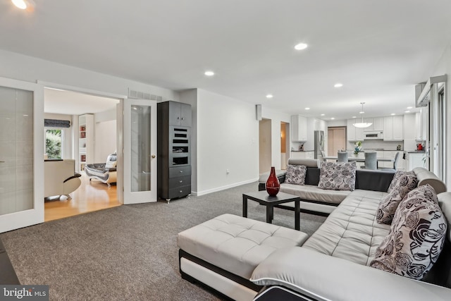 living room with carpet flooring, recessed lighting, and baseboards