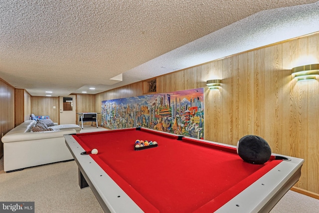 recreation room featuring billiards table, a textured ceiling, wood walls, and carpet floors
