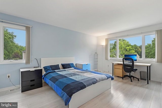 bedroom featuring wood finished floors, a desk, and baseboards