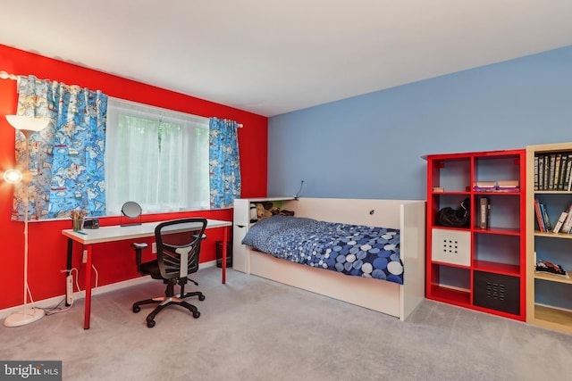 carpeted bedroom featuring an office area