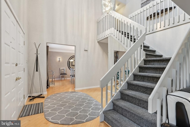 stairway featuring wood finished floors, baseboards, and ornamental molding