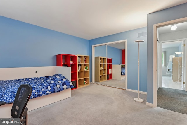 carpeted bedroom with a closet and baseboards